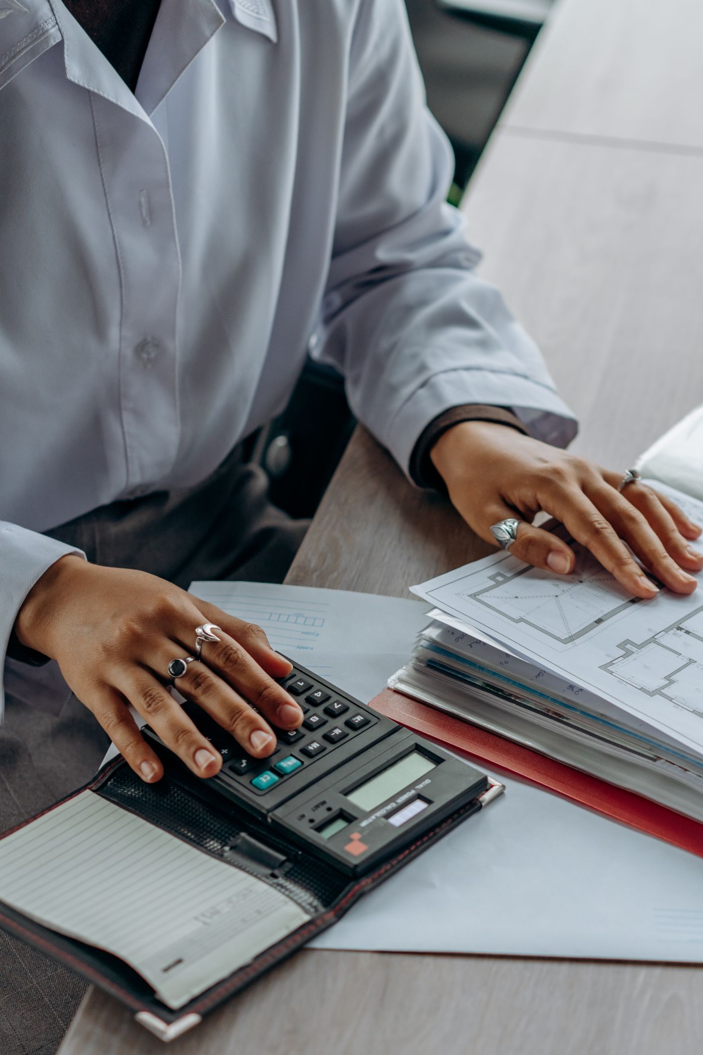 Hands using a calculator and reviewing financial documents