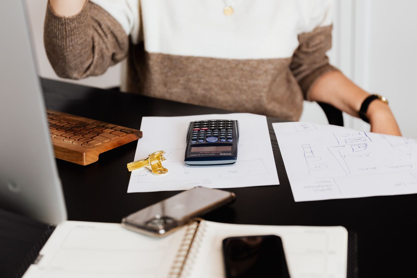 A desk with a calculator, papers and office equipment