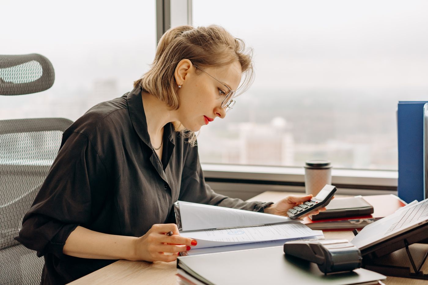 A woman calculating figures at an office desk